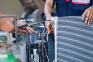 Technician working on a compresor and coils